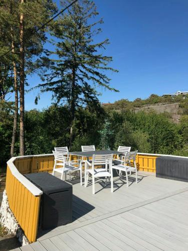 a wooden deck with a table and chairs on it at Forest Cabin By The Sea Near Fredrikstad in Kråkerøy