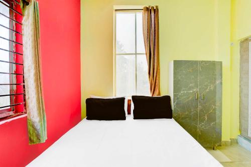 a bed in a room with a red wall at Collection O Walajapeti Vellore in Vellore