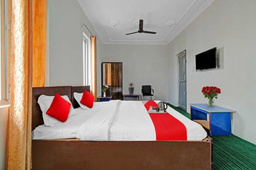 a bedroom with a large bed with red pillows at Collection O Rajbagh Post Office in Srinagar