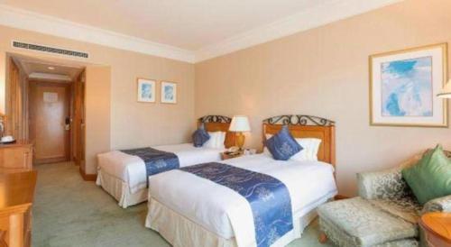 a hotel room with two beds and a couch at Regency Hotel in Shantou