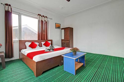a bedroom with a large bed with red pillows at Collection O Rajbagh Post Office in Srinagar