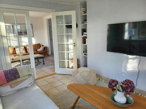 a living room with a tv on a wall at Country House With Large Garden On Langeland in Humble