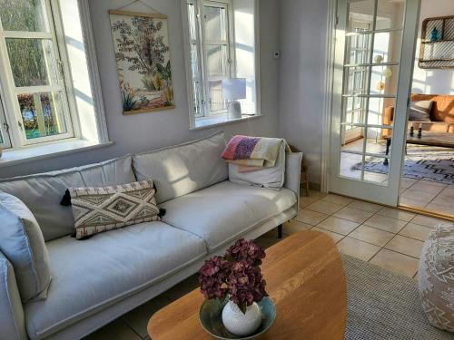 a living room with a couch and a table at Country House With Large Garden On Langeland in Humble