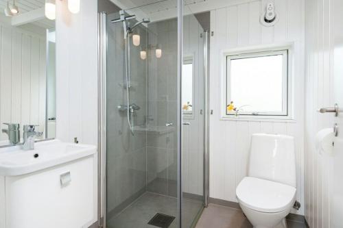 Un baño con ducha, inodoro y lavabo. en Seaside Cabin With Ocean View And Sunny Terrace, en Søgne