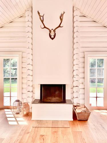 a living room with a fireplace and antlers on the wall at Nordic Exclusive Log House On The North Coast in Tisvildeleje