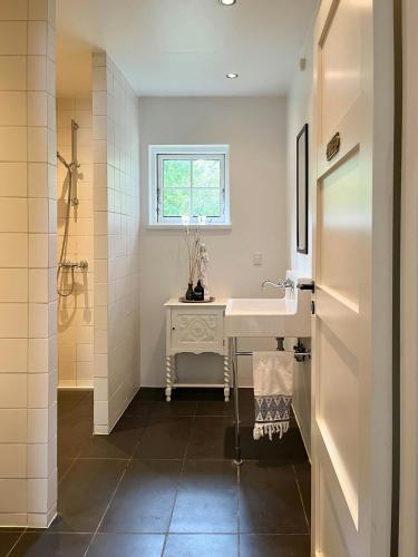 a bathroom with a sink and a window at Classic 30S House In Asserbos Woods in Frederiksværk
