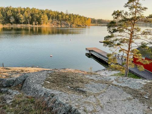 a dock on a lake with trees in the background at Cabin With Private Beach At Ingarö in Skenora