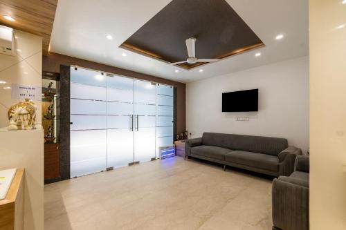a living room with a couch and a tv at RR Residency in New Delhi