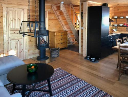 a living room with a fireplace in a log cabin at Family Cabin With Norefjell Mountain Views in Lampeland