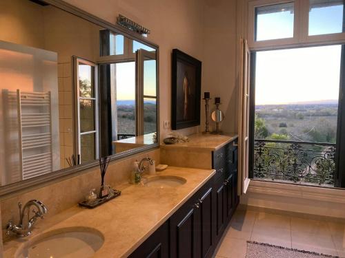 La salle de bains est pourvue de 2 lavabos et d'une grande fenêtre. dans l'établissement Elegant Retreat With Pool Near Mediterranean Coast, à Florensac