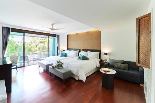 a bedroom with a large bed and a couch at Loligo Resort Hua Hin in Hua Hin