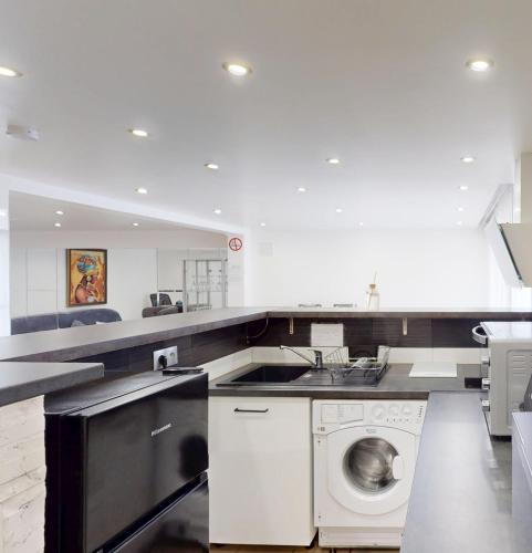 une cuisine avec une machine à laver et un évier dans l'établissement Kimia House appartement spacieux, à Osny