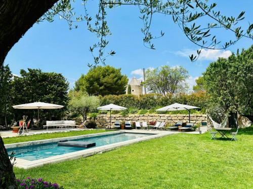 une piscine avec chaises et parasols dans une cour dans l'établissement Peaceful Apartment In The Heart Of Ventabren, à Ventabren
