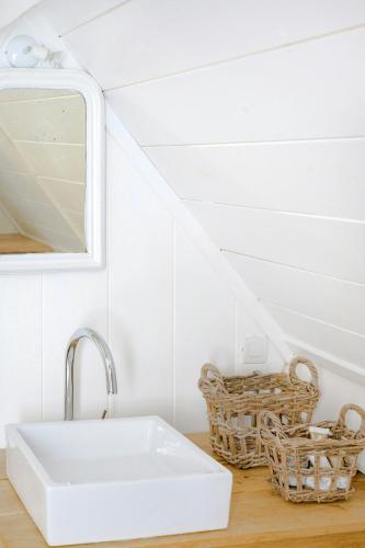 La salle de bains est pourvue d'un lavabo et de paniers. dans l'établissement House With View In The Heart Of Auvergne, à Murol