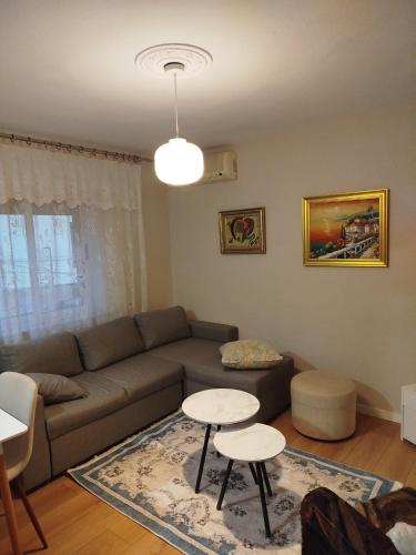 ein Wohnzimmer mit einer Couch und zwei Tischen in der Unterkunft Klejdo apartment in Tirana
