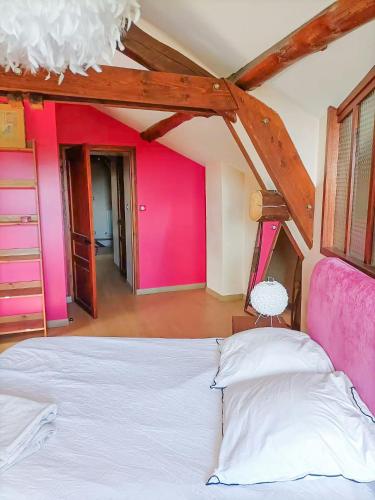 une chambre avec un lit blanc et un mur rose dans l'établissement Family Home In The Heart Of Beaujolais, à Régnié