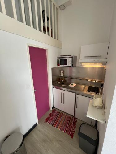 - une petite cuisine avec une porte violette dans une chambre dans l'établissement Maison accès plage dans résidence avec Piscine, à Bretignolles-sur-Mer