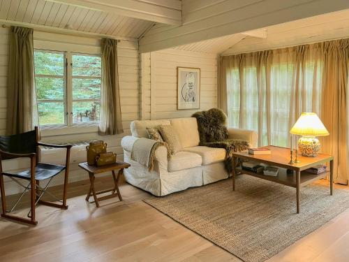 a living room with a couch and a table at Summerhouse In Forest Near Rørvig Beach in Nykøbing Sjælland