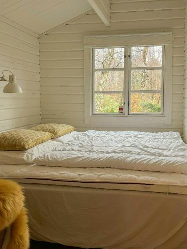 a large bed in a room with a window at Summerhouse In Forest Near Rørvig Beach in Nykøbing Sjælland