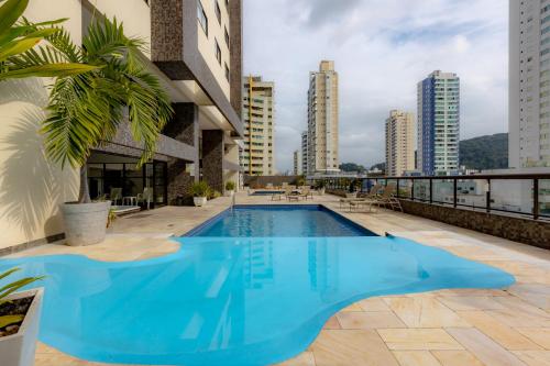 a large blue swimming pool on the roof of a building at PROMOÇÃO - Vista Superior - Jacuzzi - Sauna - Piscina - Vaga Grátis 400m da Praia in Balneário Camboriú