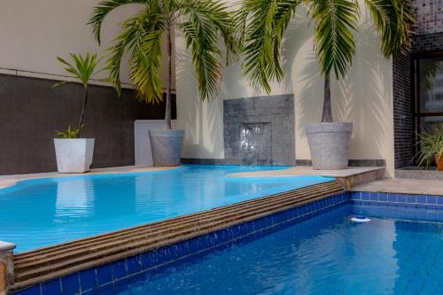 a swimming pool with two palm trees and a fireplace at PROMOÇÃO - Vista Superior - Jacuzzi - Sauna - Piscina - Vaga Grátis 400m da Praia in Balneário Camboriú