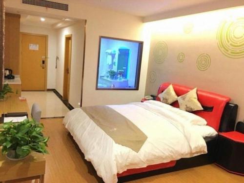 a bedroom with a large bed and a red chair at GreenTree Inn Nantong University Industrial Expo City Express Hotel in Nantong