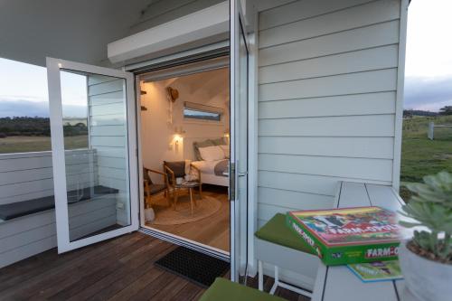 a sliding glass door on a house with a bedroom at Banjos Cabin Gippsland - Luxury Eco Stay - King Bed, Pond Valley Views, Fireplace in Seaton