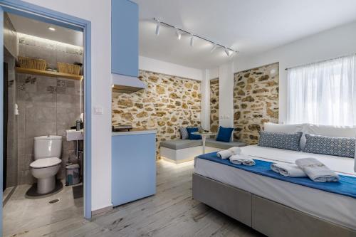 a bedroom with a large bed and a bathroom at Le Petit Bati Blue in Skopelos Town