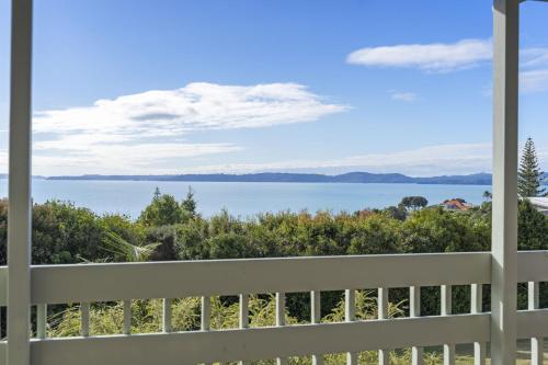 a view of the water from the balcony of a house at Maraetai Yacht Club in Maraetai