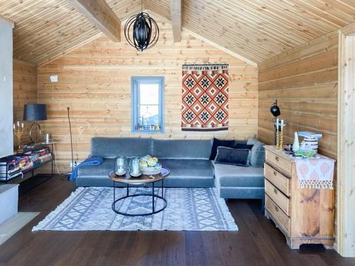 a living room with a blue couch and a table at Fantastisk Familiehytte Nær Geilo in Geilo