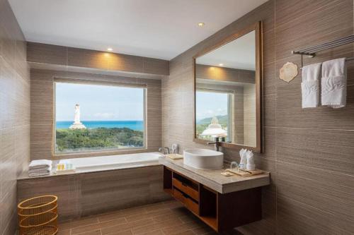 a bathroom with a tub and a sink and a window at Nanshan Leisure Villas in Shangsimacun
