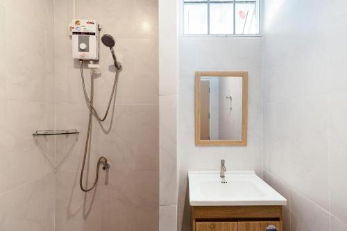 a bathroom with a shower and a sink and a mirror at Sanipa Resort Rayong in Ban Noen Phra