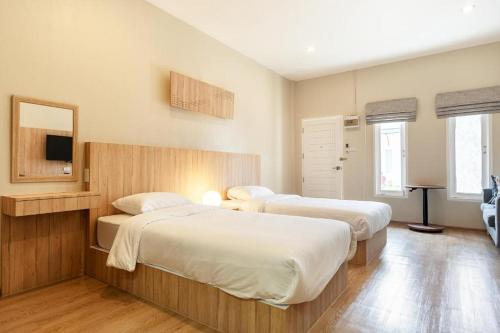 a bedroom with two beds and a television in it at Sanipa Resort Rayong in Ban Noen Phra
