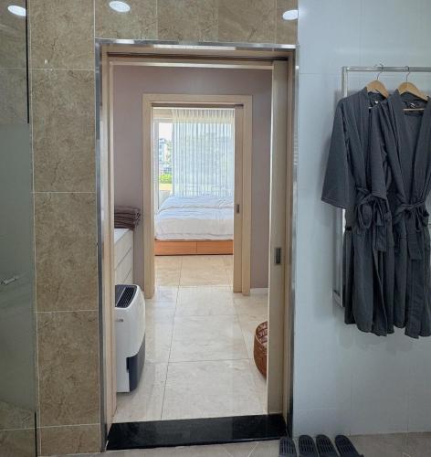 a bathroom with a walk in shower and a bedroom at Ocean View Private Pool Villa in Jeju