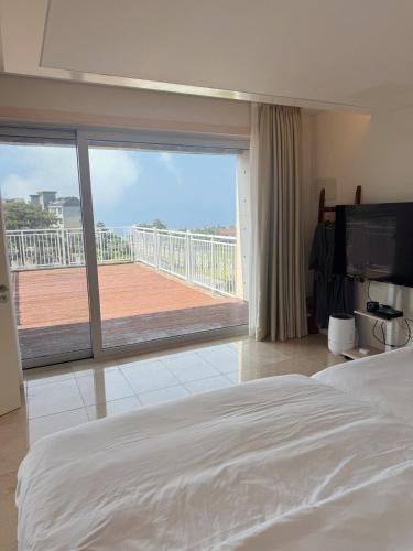 a bedroom with a large bed and a large window at Ocean View Private Pool Villa in Jeju