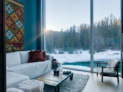 een woonkamer met een bank, een tafel en een raam bij Hytte Ved Heimsila I Hemsedal in Hemsedal