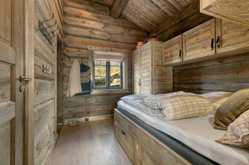 a bedroom with a bed in a wooden cabin at Cabin With Panoramic View Over Hardangervidda in Dagali