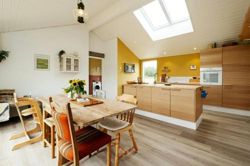 eine Küche und ein Esszimmer mit einem Holztisch und Stühlen in der Unterkunft Family House With Sauna Near Ålbæk in Ålbæk