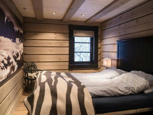オップダールにあるSpacious Mountain Cabin With Lodge Style In Oppdalの木製の壁の部屋にあるベッドのある寝室