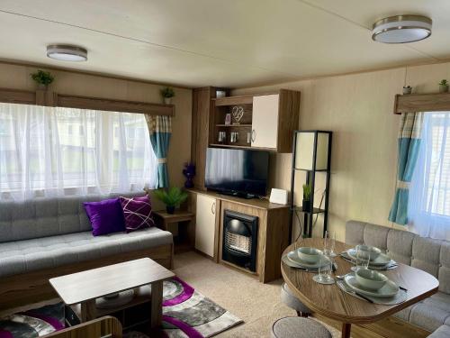 a living room with a couch and a table at 275 - Butlins Skegness, pet friendly and WiFi - Meadow Lakes Caravan & Lodge Hire in Ingoldmells
