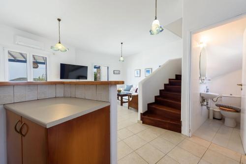 a kitchen and living room with a toilet and a staircase at Villa Drios Semeli Paros in Drios