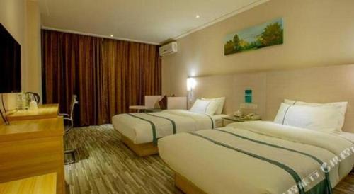 a hotel room with two beds and a desk at City Comfort Inn Nanning Zoo Keyuan Avenue in Nanning