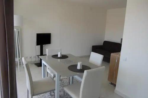 un salon avec une table et des chaises blanches dans l'établissement Studio 3 mn plage Climatisé Antibes juan les pins, au Golfe-Juan