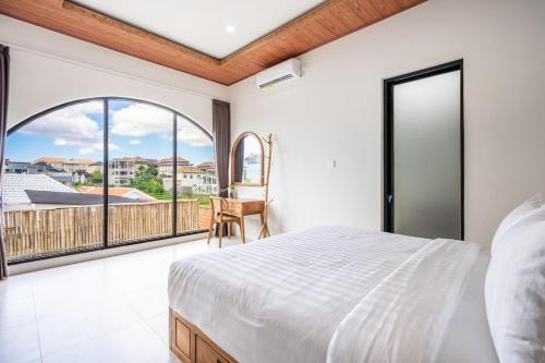 a bedroom with a bed and a large window at Villa The ARK - A by OriVista in Dalung