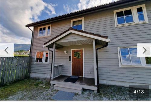 una casa blanca con una puerta y una valla en Rom i bofelleskap, en Sogndal