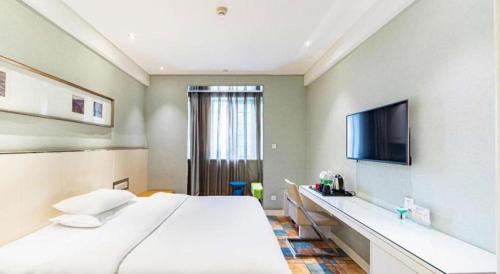 a bedroom with a large bed and a flat screen tv at Zaozhuang Hotel in Zaozhuang