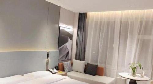 a bedroom with a bed and a table and a window at Zaozhuang Hotel in Zaozhuang