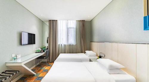 a hotel room with two beds and a desk at Zaozhuang Hotel in Zaozhuang