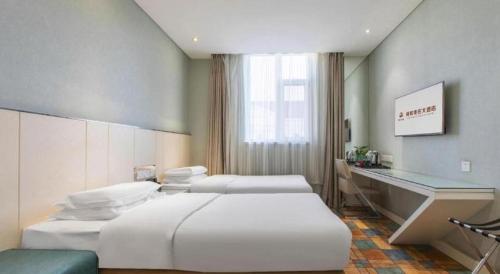 a hotel room with two beds and a desk at Zaozhuang Hotel in Zaozhuang