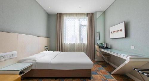 a bedroom with a large bed and a desk at Zaozhuang Hotel in Zaozhuang